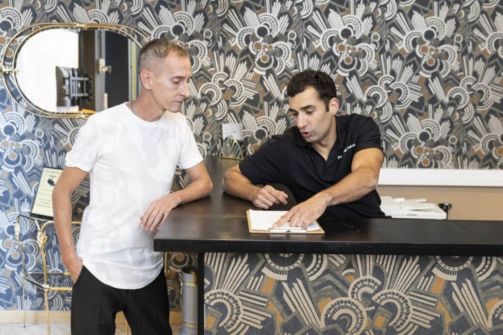 Entrenador personal asesora a un cliente sobre dieta y nutrición en la recepción de nuestro estudio de Barcelona