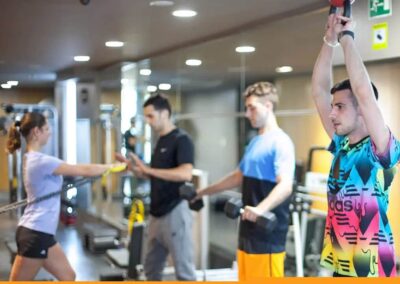Entrenador personal corrige a una clienta durante un remo con polea en nuestro estudio de Barcelona